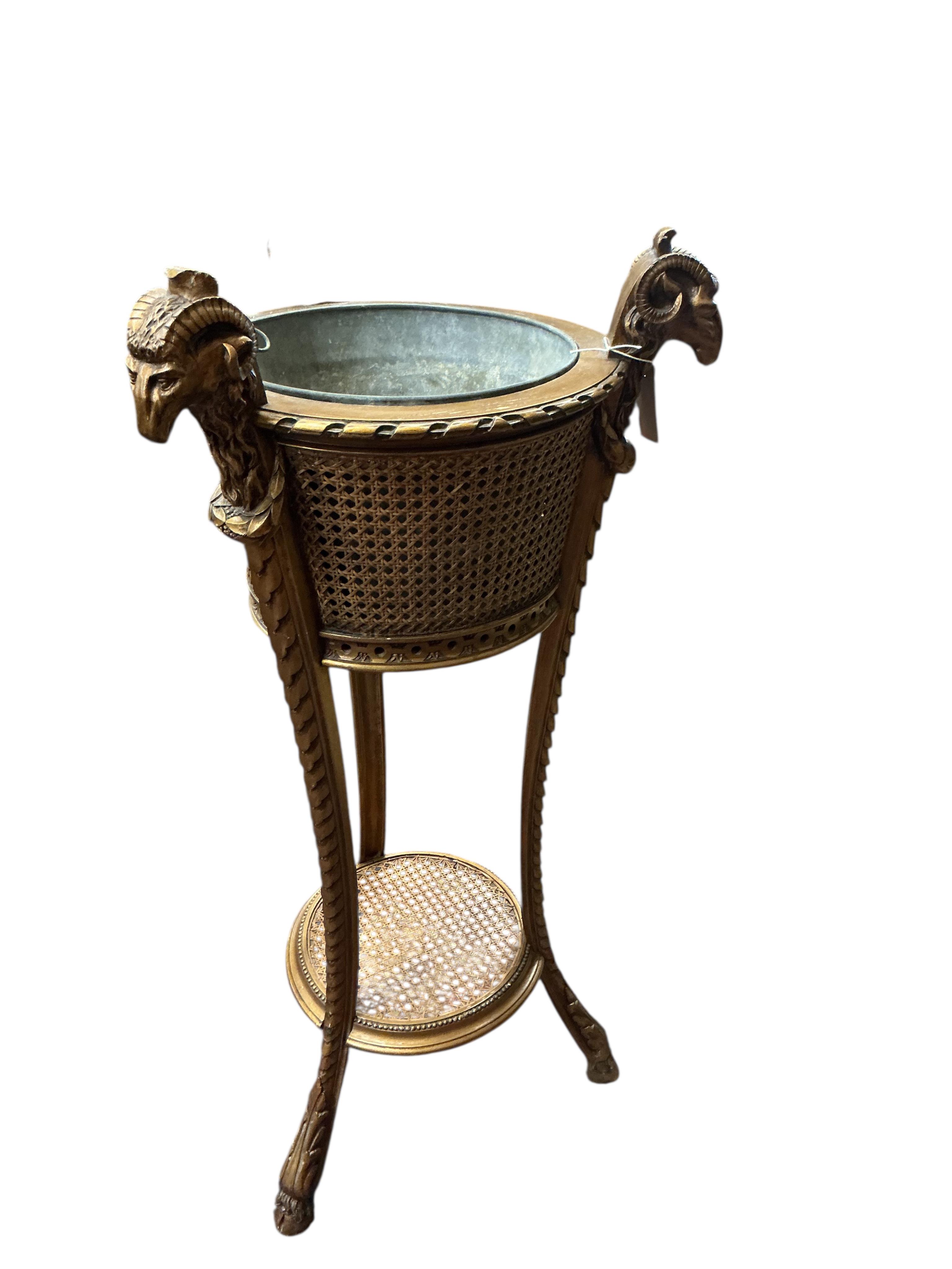 A Victorian style caned giltwood jardiniere with ram's head finials, height 99cm